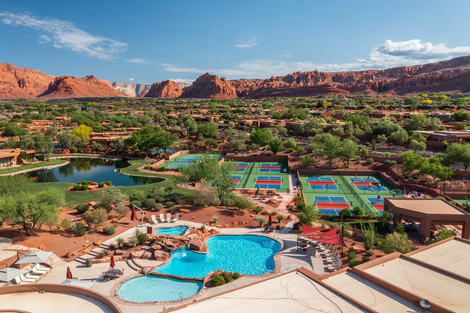 Aerial view of Entrada pools, sports courts and red-rock surroundings