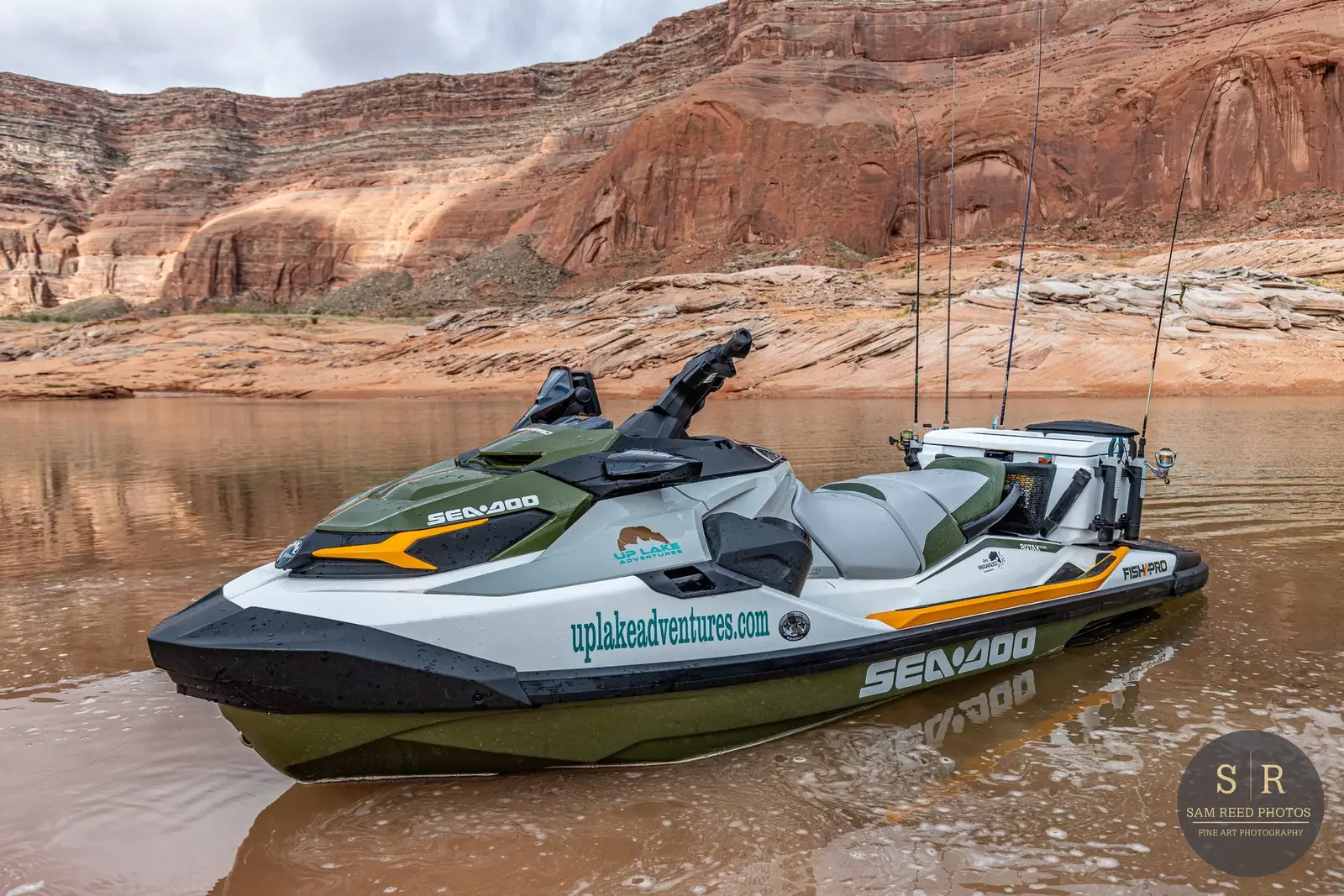 A Sea-Doo jet ski floating on a lake with rocky, red canyon cliffs in the background.