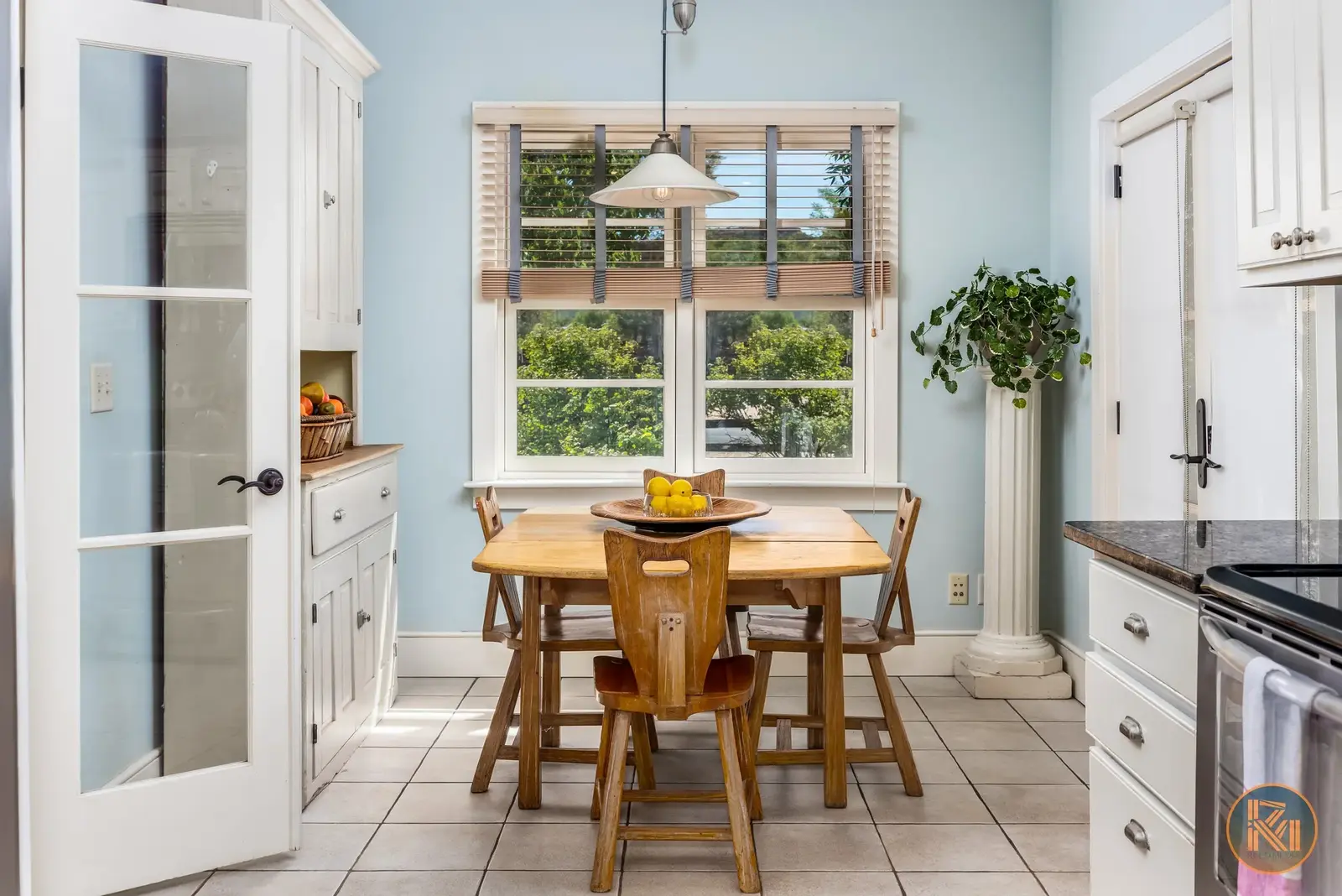 Kitchen dining nook with a wooden table and chairs beneath a window.