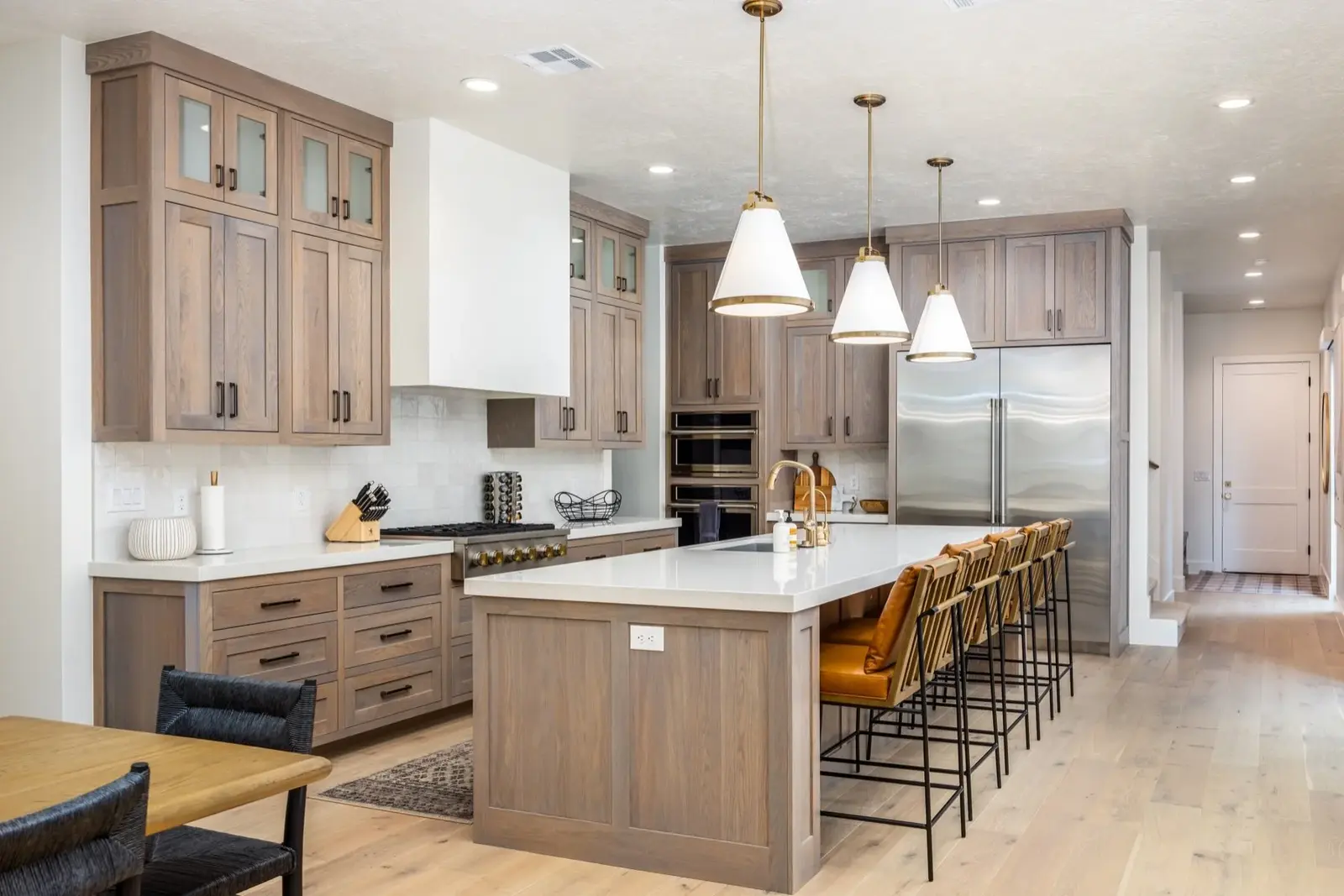 Lula Bay — Kitchen island with wood cabinetry and pendant lights