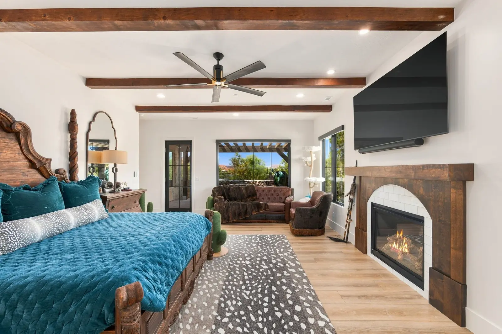 Bedroom with teal bedding, exposed ceiling beams and a fireplace
