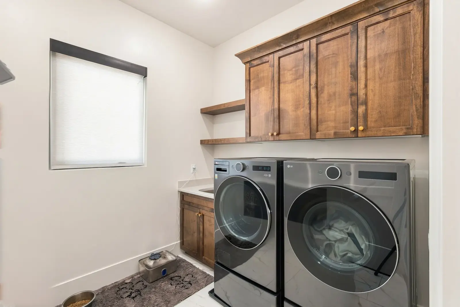 Laundry room with wood cabinets and a front-loading washer and dryer