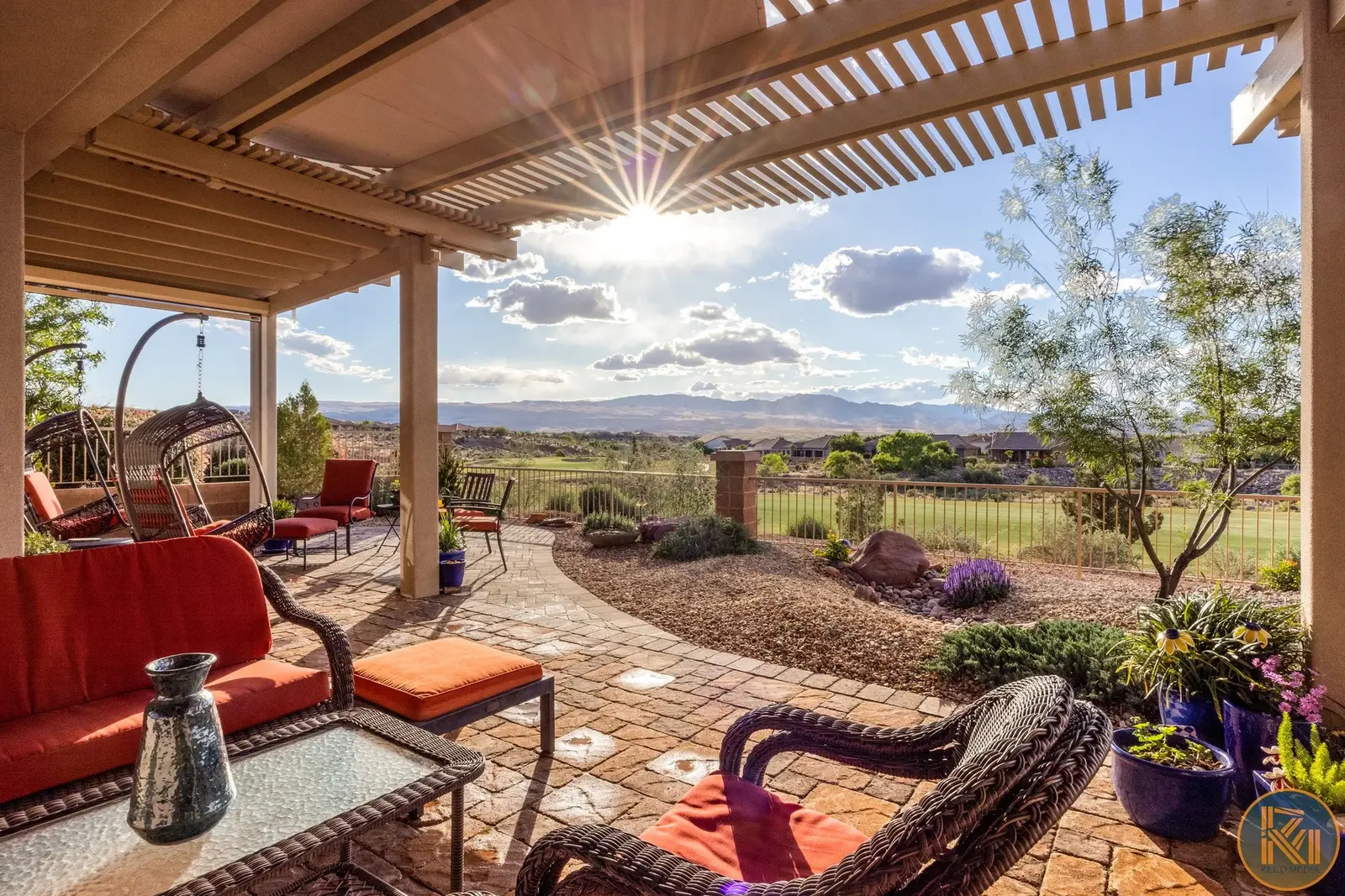 Covered patio with red cushions overlooking landscaped grounds — from Sam Reed’s photography portfolio