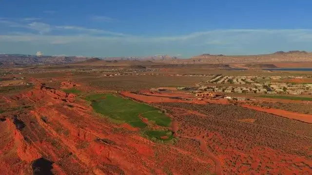 Still from Sam Reed drone video of red-rock terrain and surrounding homes