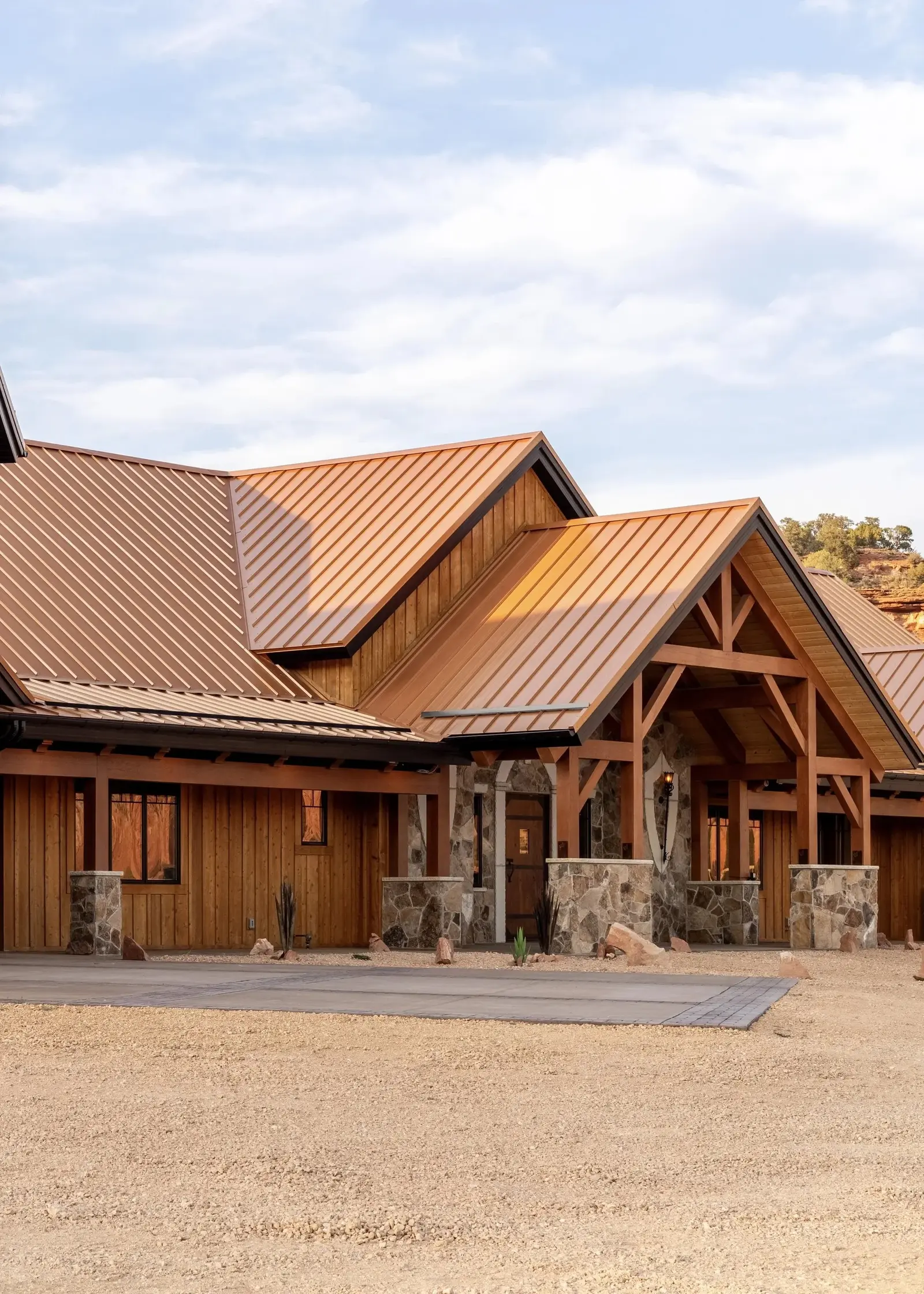 Wood-and-stone home exterior with a metal roof, from Sam Reed’s portfolio