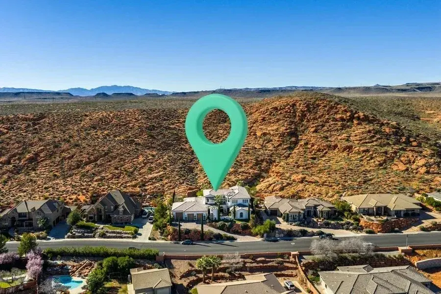 Aerial view of homes below red desert hills photographed by Sam Reed
