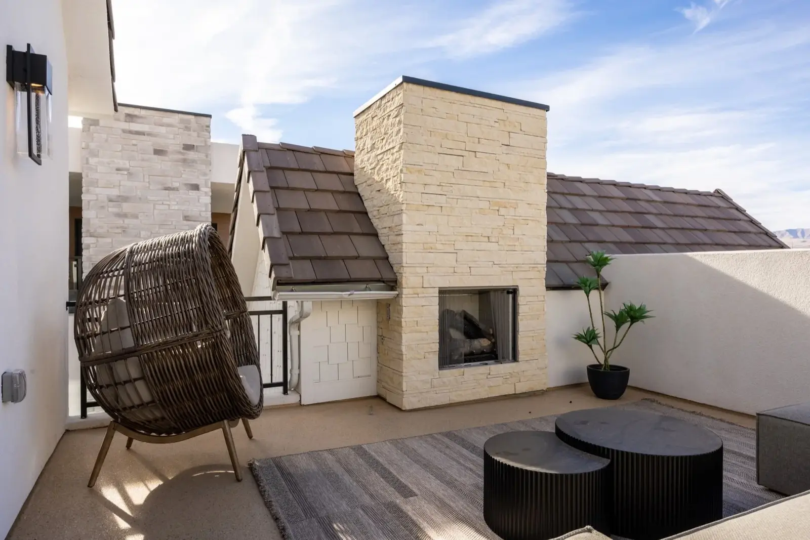 Lula Bay — Rooftop lounge with a stone outdoor fireplace