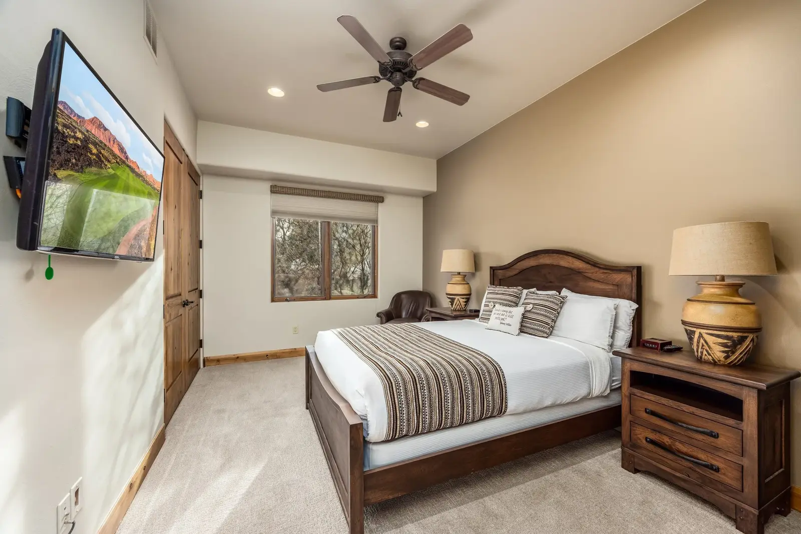 Guest bedroom with wood furnishings and a ceiling fan at The Inn at Entrada