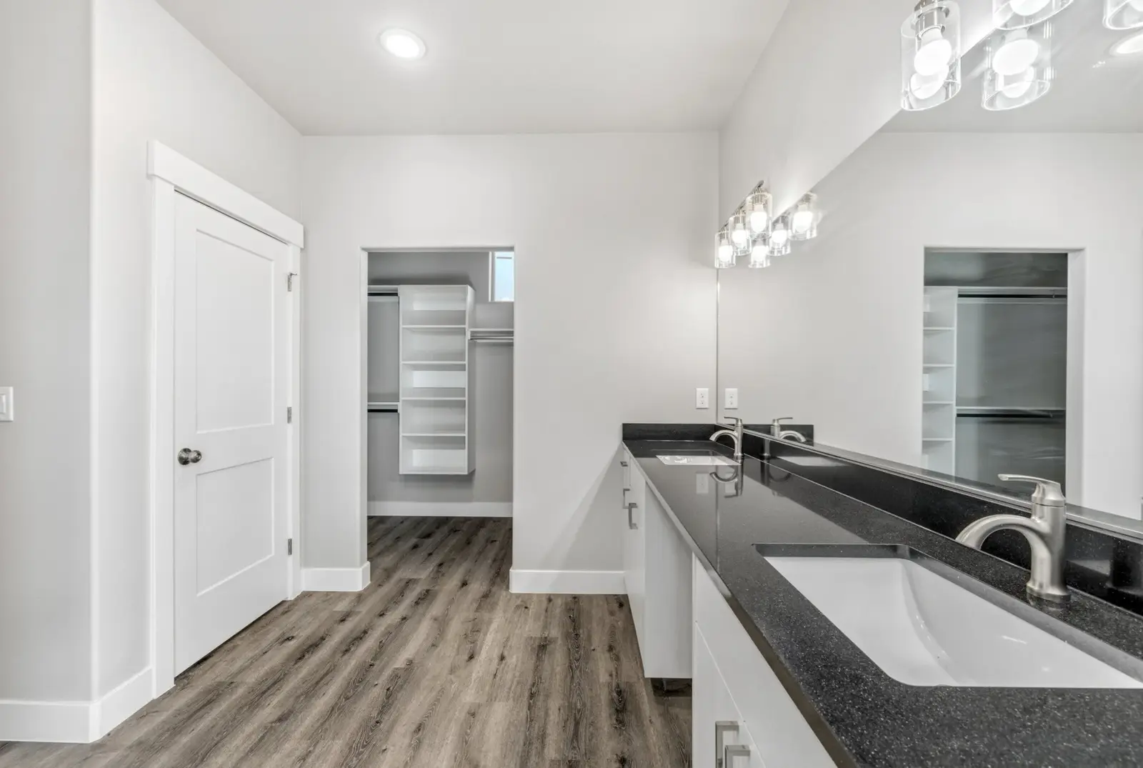 Bathroom with double sinks, a large mirror and an adjoining closet