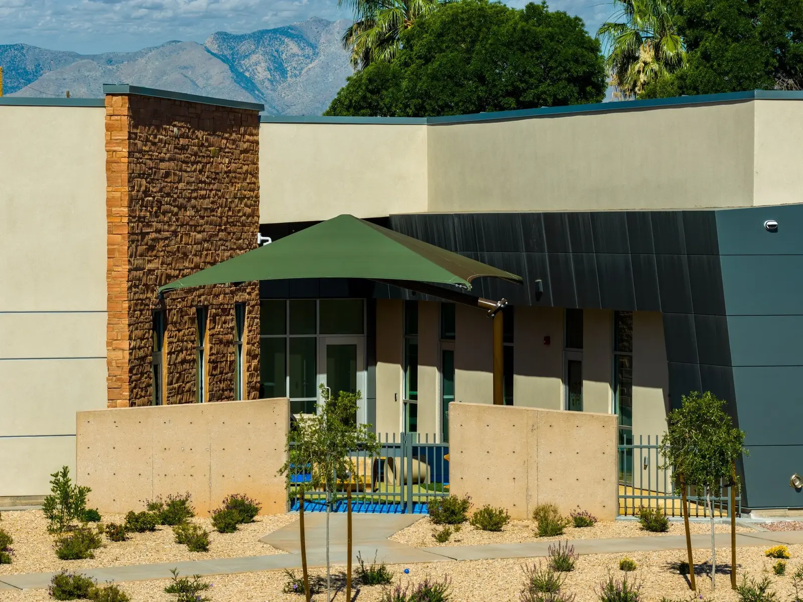 Shaded outdoor area beside the stone and blue-gray exterior walls.