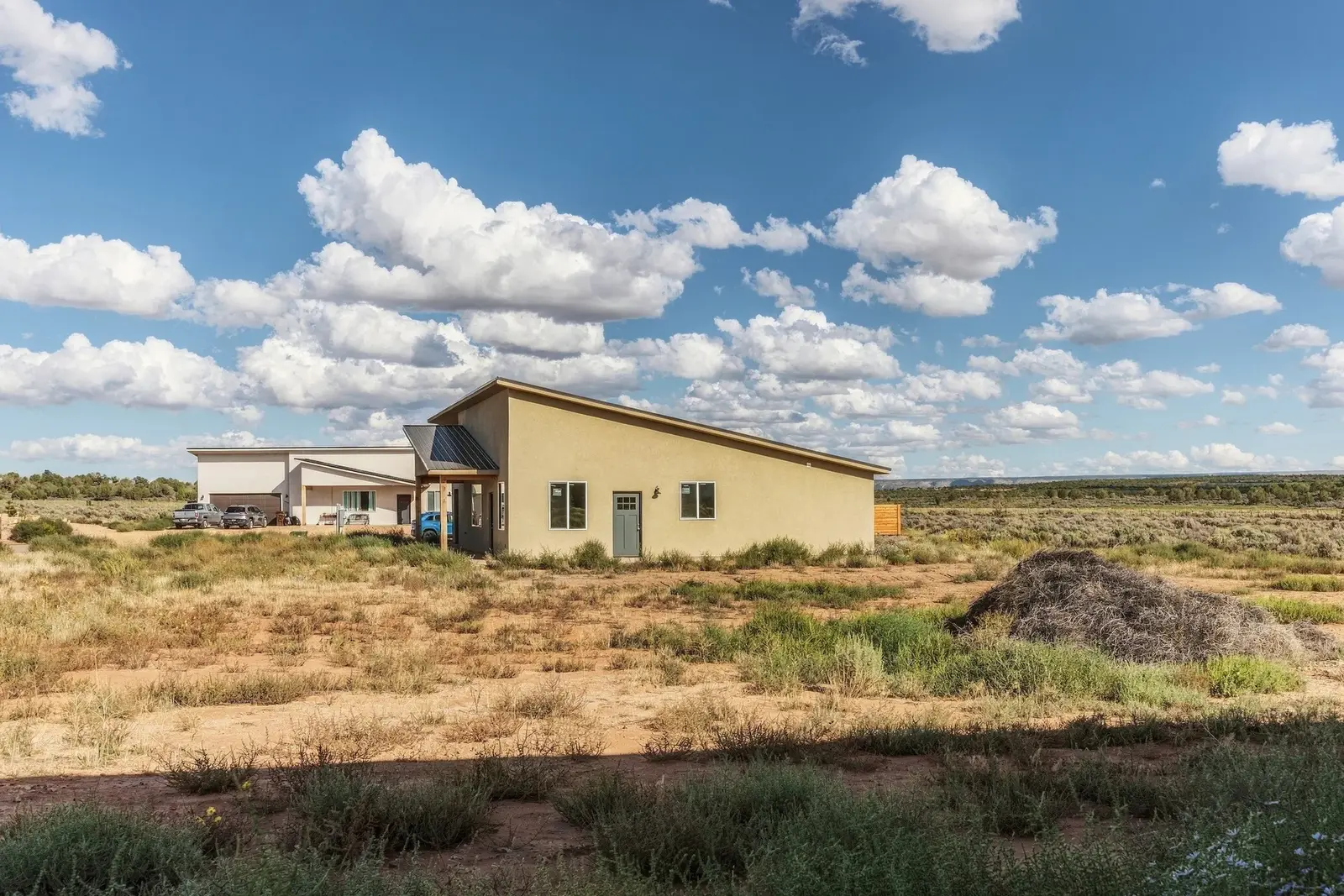 Home exterior surrounded by desert vegetation under a blue sky