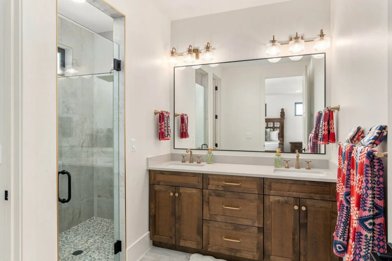 Bathroom with a wood vanity, a large mirror and a glass shower enclosure