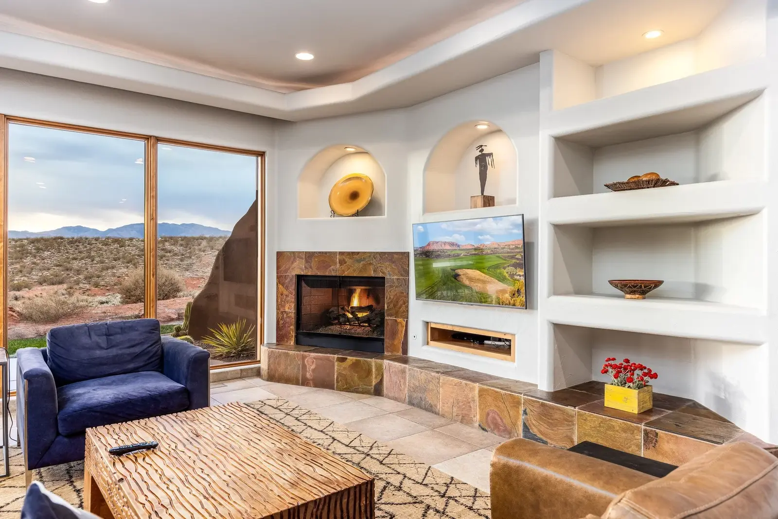 Living room with a fireplace and patio views at The Inn at Entrada