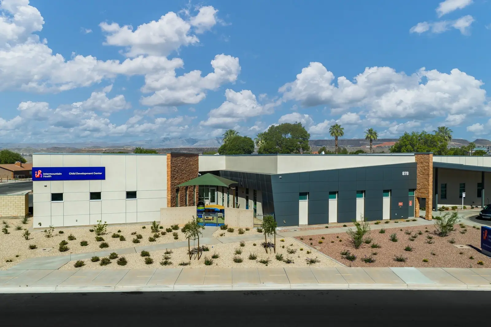 Long exterior elevation with shaded windows and desert planting.