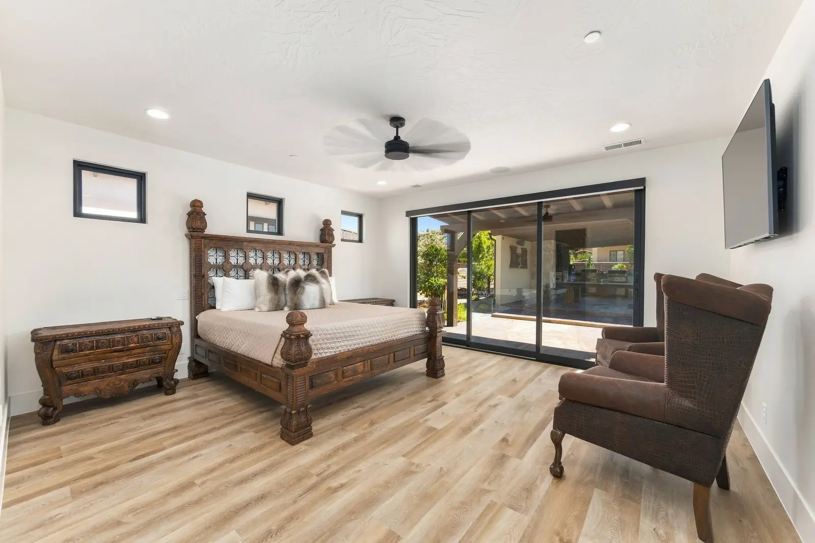 Furnished bedroom with sliding doors opening toward an outdoor seating area