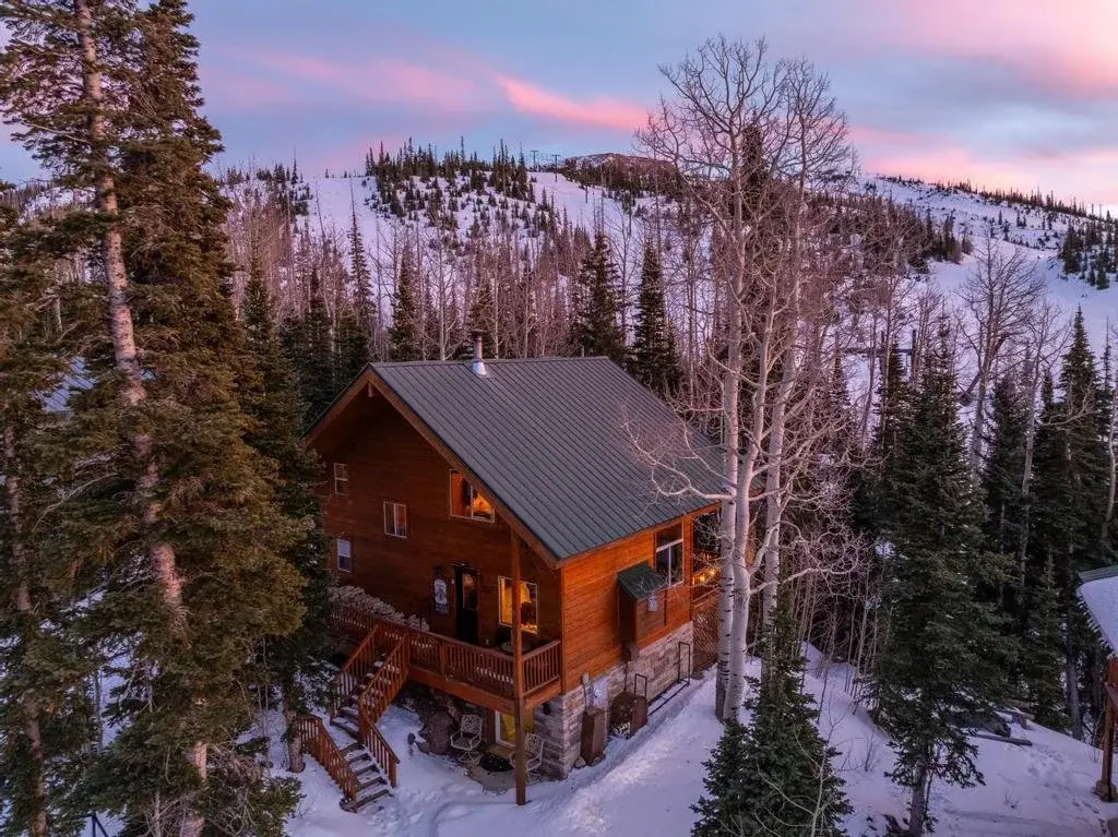 Timber cabin among snowy evergreens at dusk in Brian Head — photographed by Sam Reed