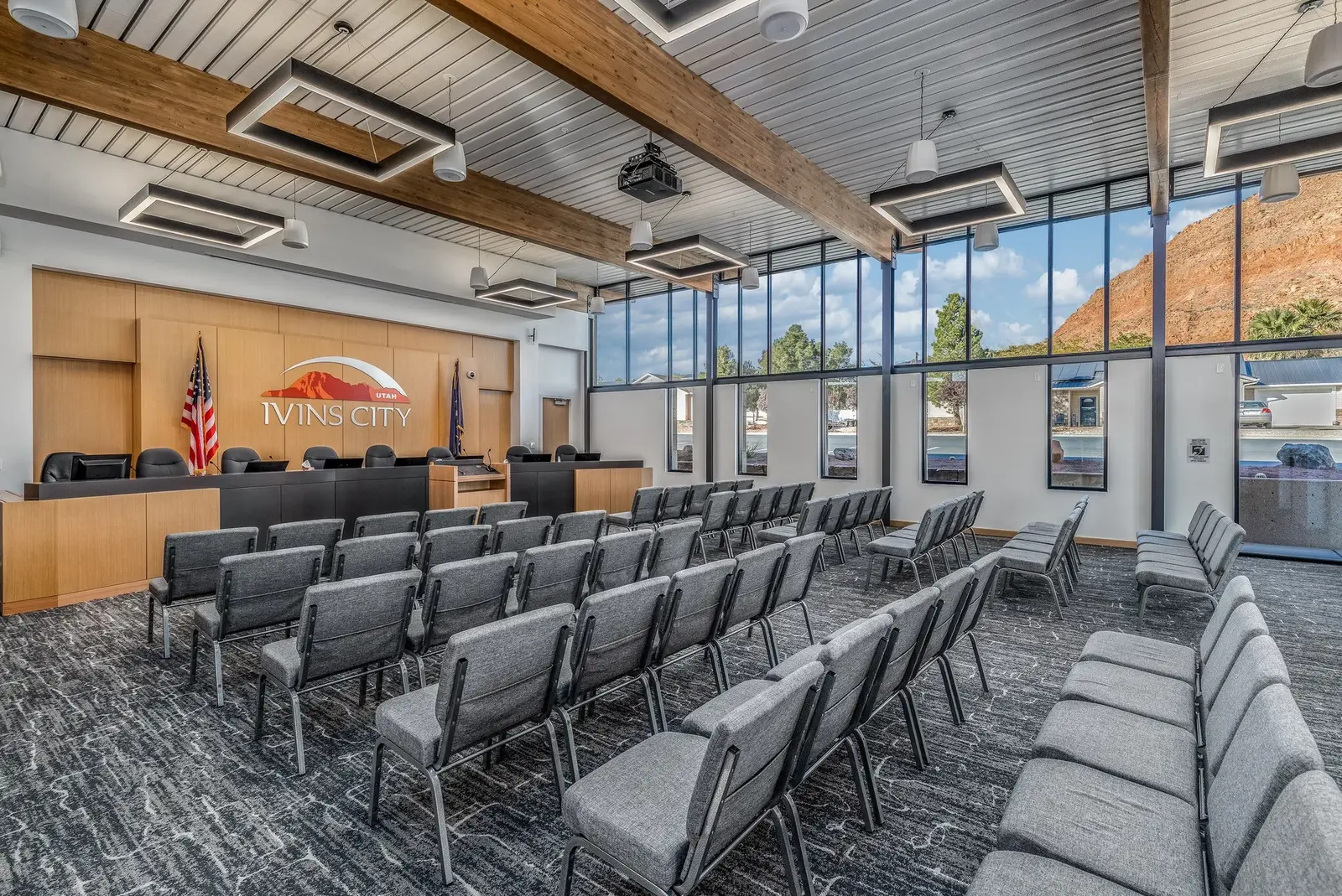 Ivins City Council chamber with rows of seating and tall windows.
